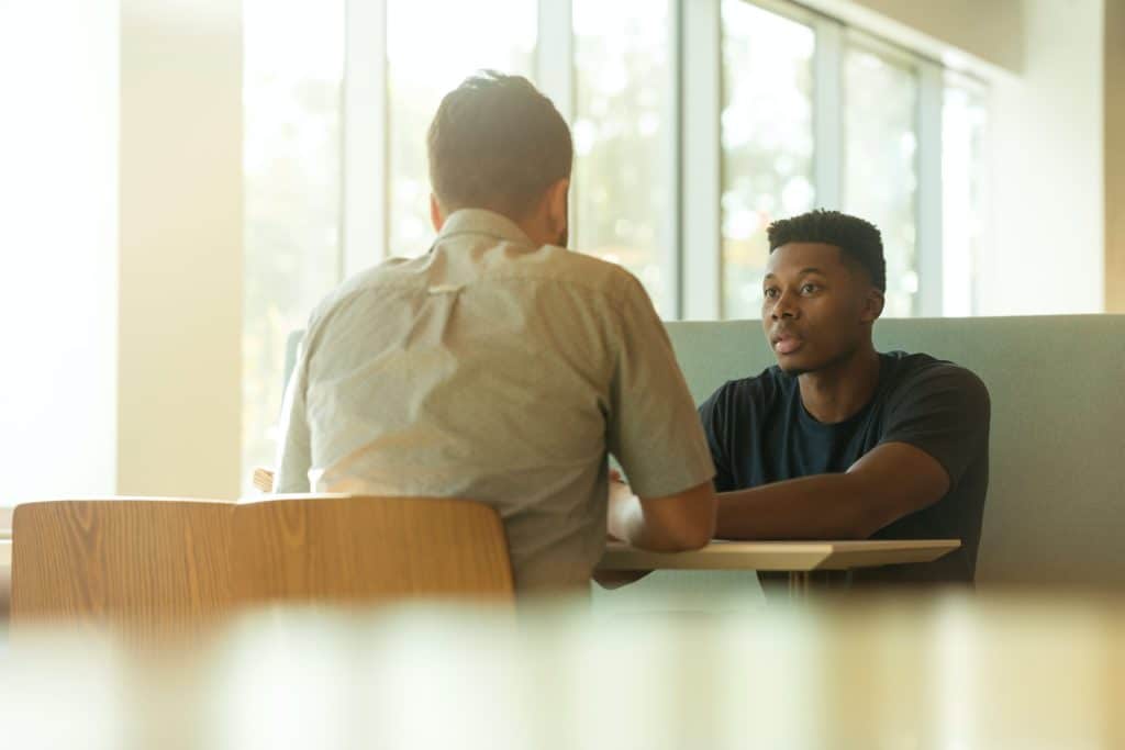 Two men having a conversation at work