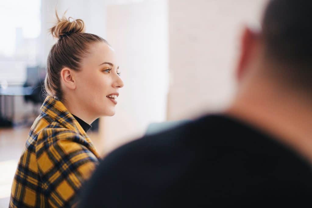 Photo of woman addressing colleagues in a meeting